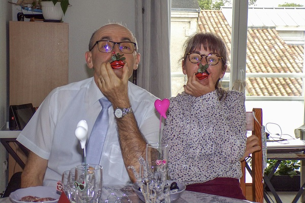 Photo of a couple sitting at a table with party whistles