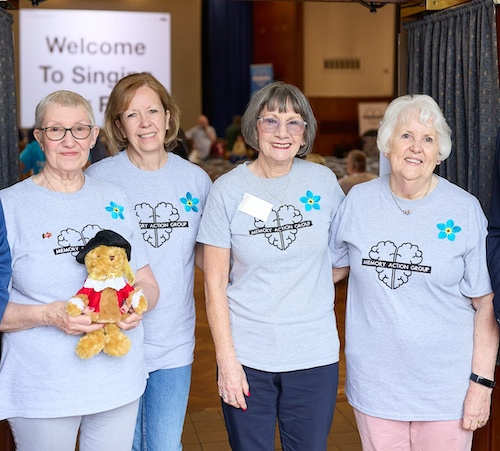 Photo of volunteers holding teddy bear