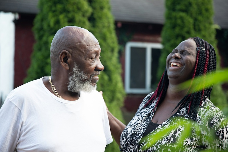 Photo of a couple in a garden, the woman is laughing